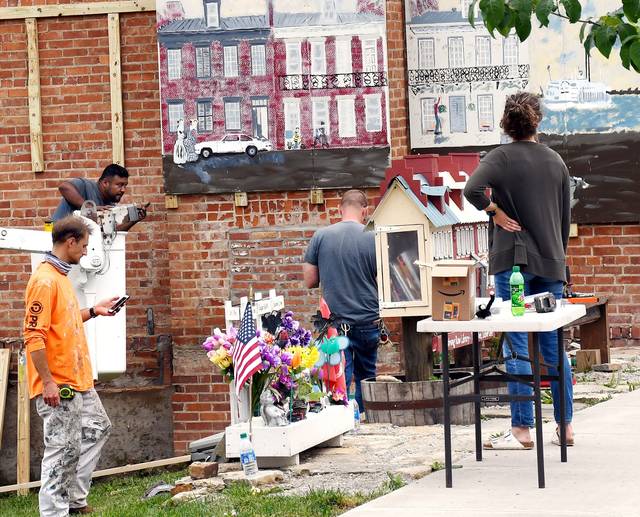 127092632_web1_installmurals
David Darmitzel, in the orange shirt, and city workers Ernesto Garcia and Richard Heber install the Armstrong Row panels.