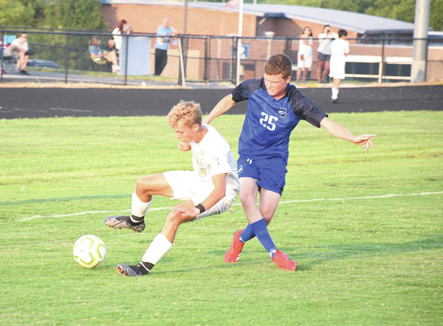 Mason Countys Colby Doyle (blue) battles with Rowan Countys Blake Mullen for possession during the first half of Tuesday nights game. The Vikings won the season opener for both teams, 6-1. (Evan Dennison, The Ledger Independent)